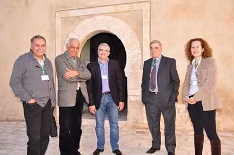 Un groupe de congressistes devant une porte ancienne.